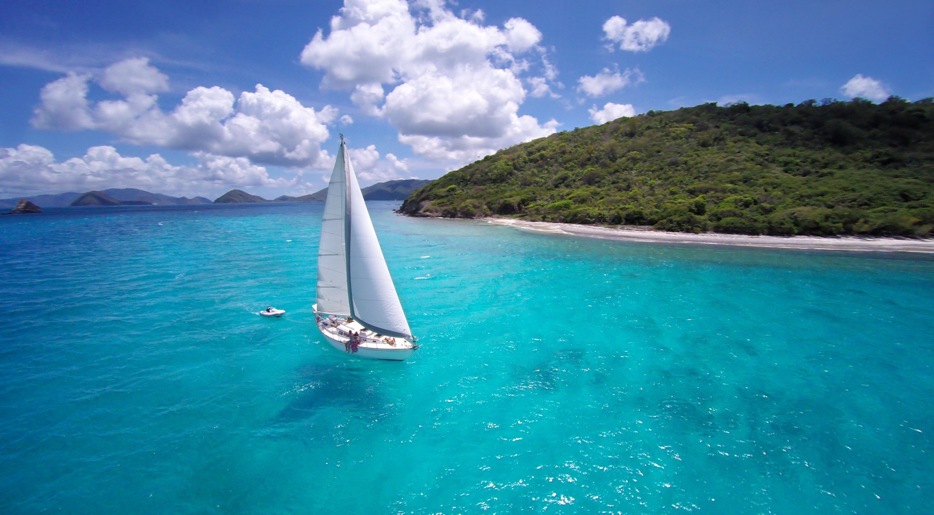 aerial view of a sloop sailing through the Caribbean